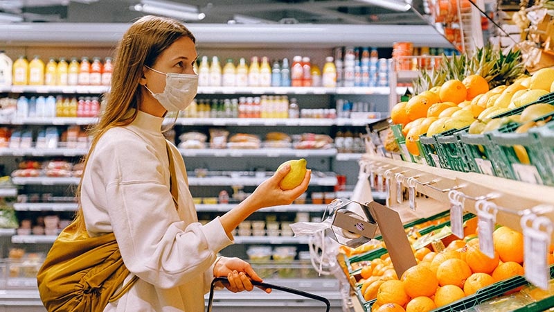 woman wearing mask while produce shopping